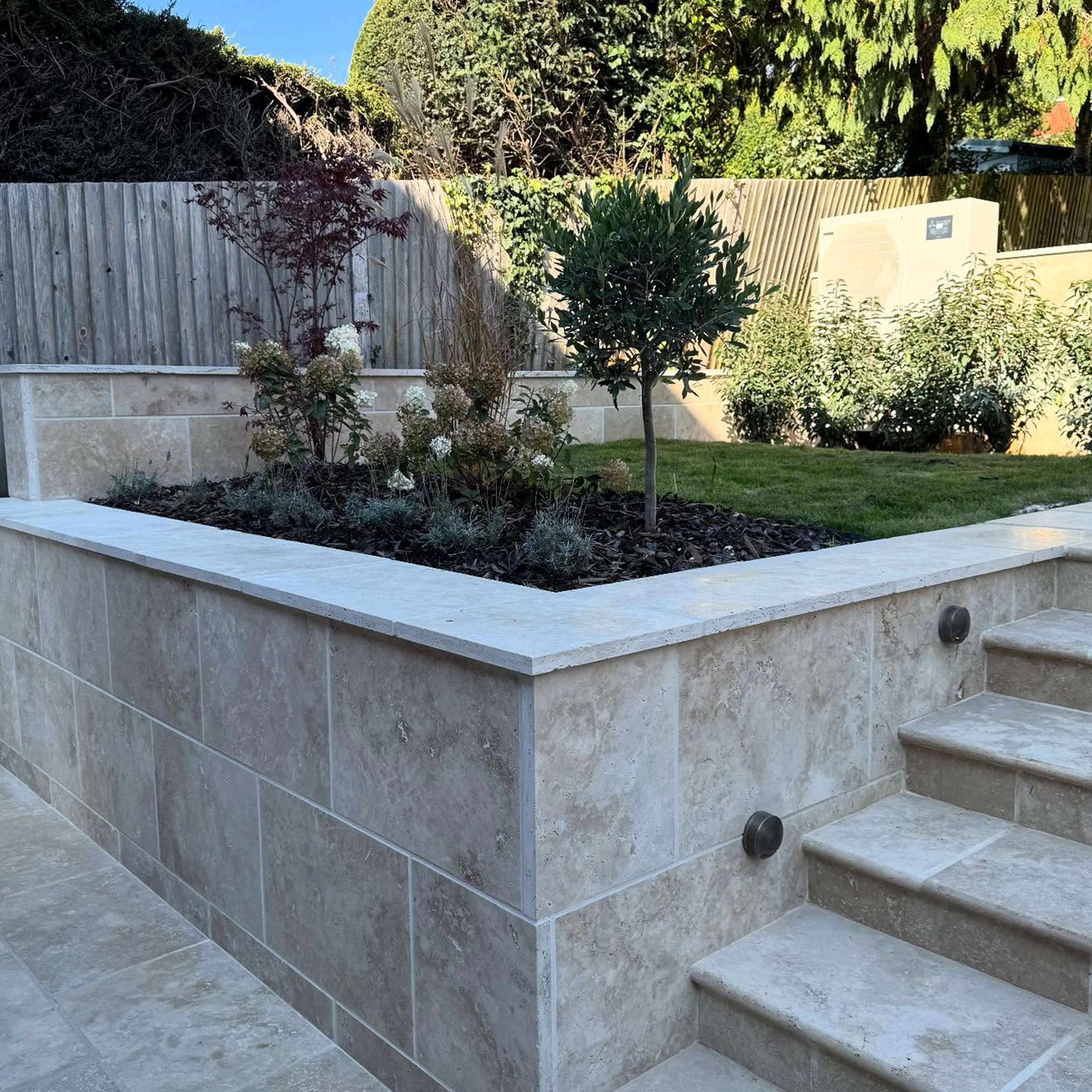 A concrete planter with steps leading up to it.
