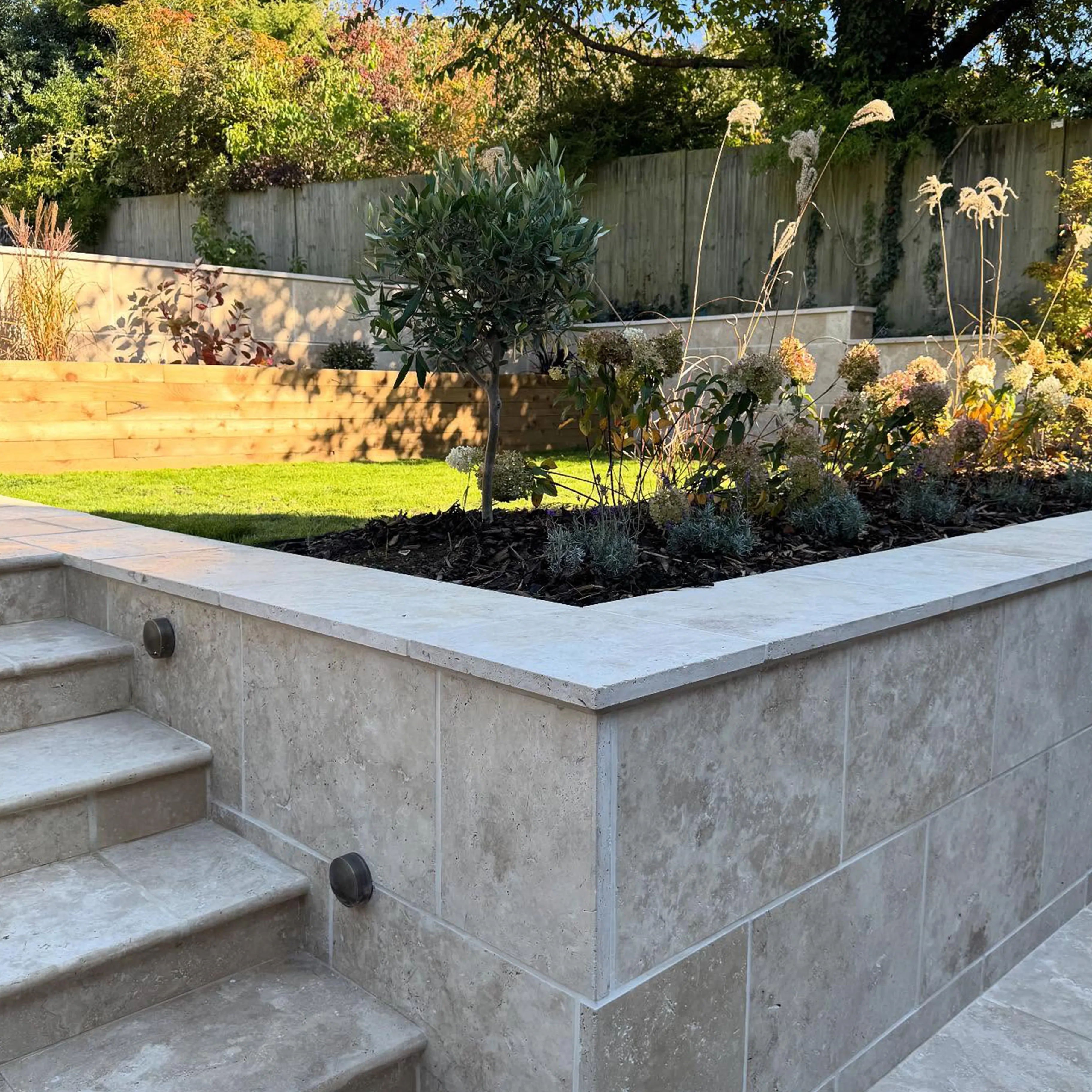 A concrete planter with steps leading up to it.