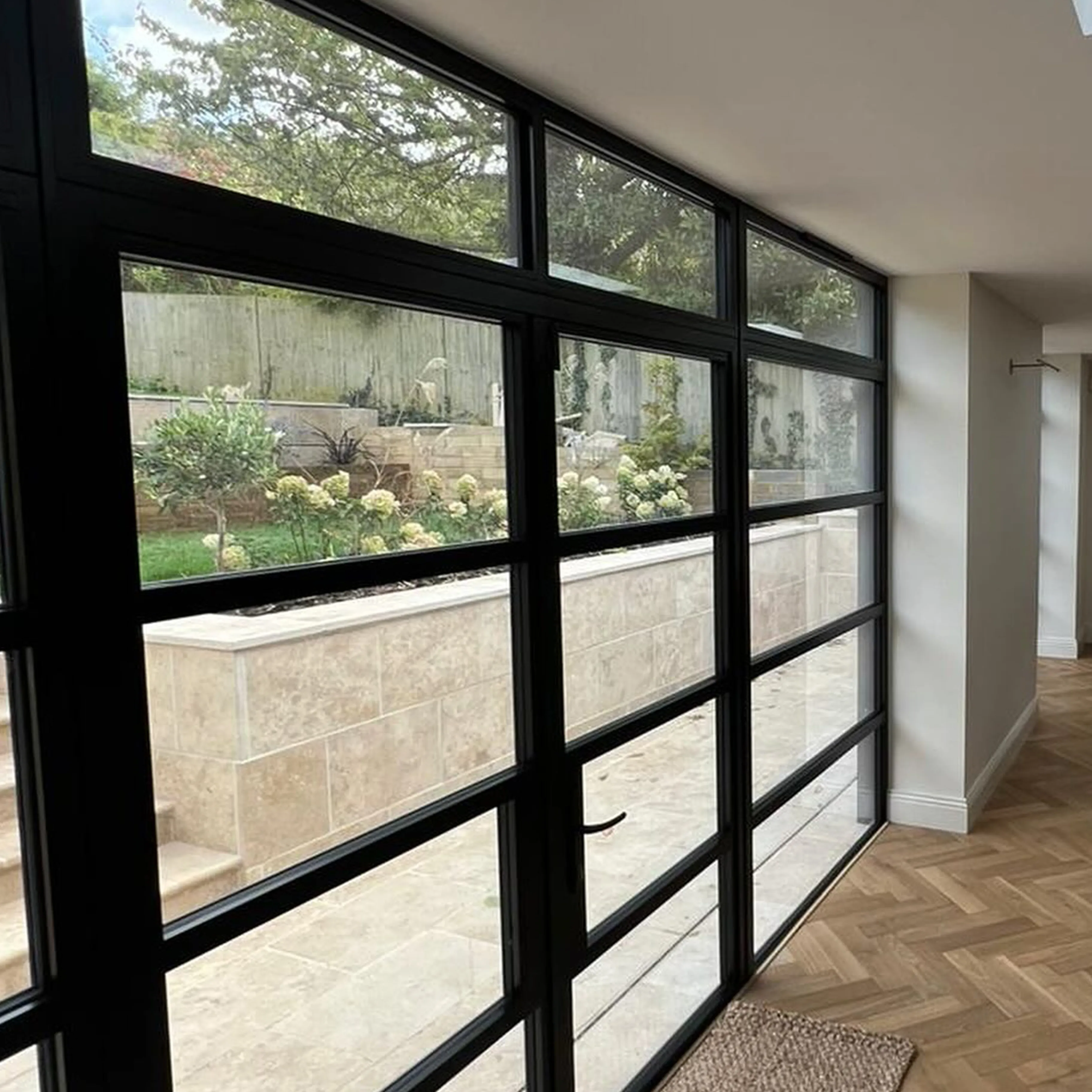 A room with a lot of windows and a wooden floor.