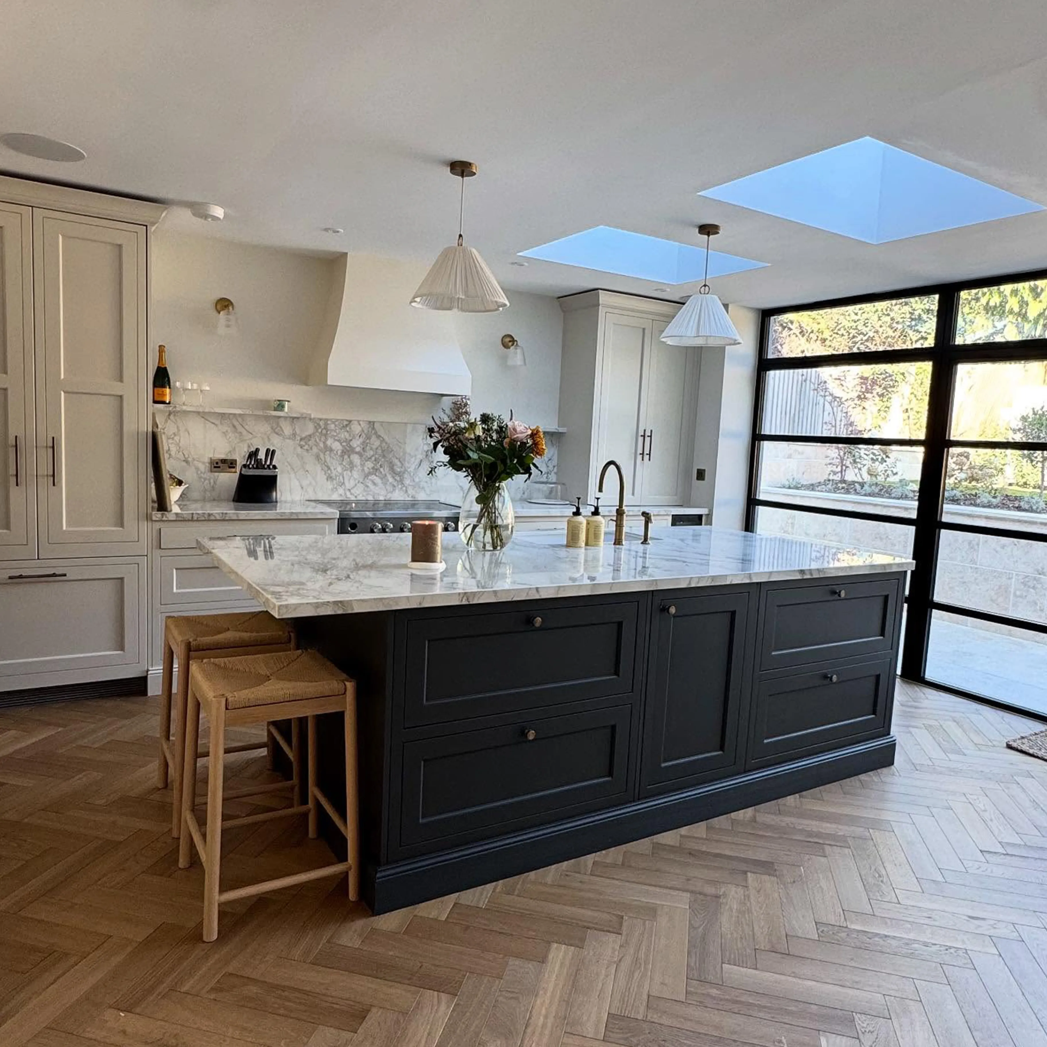 A large kitchen with a center island and two stools.