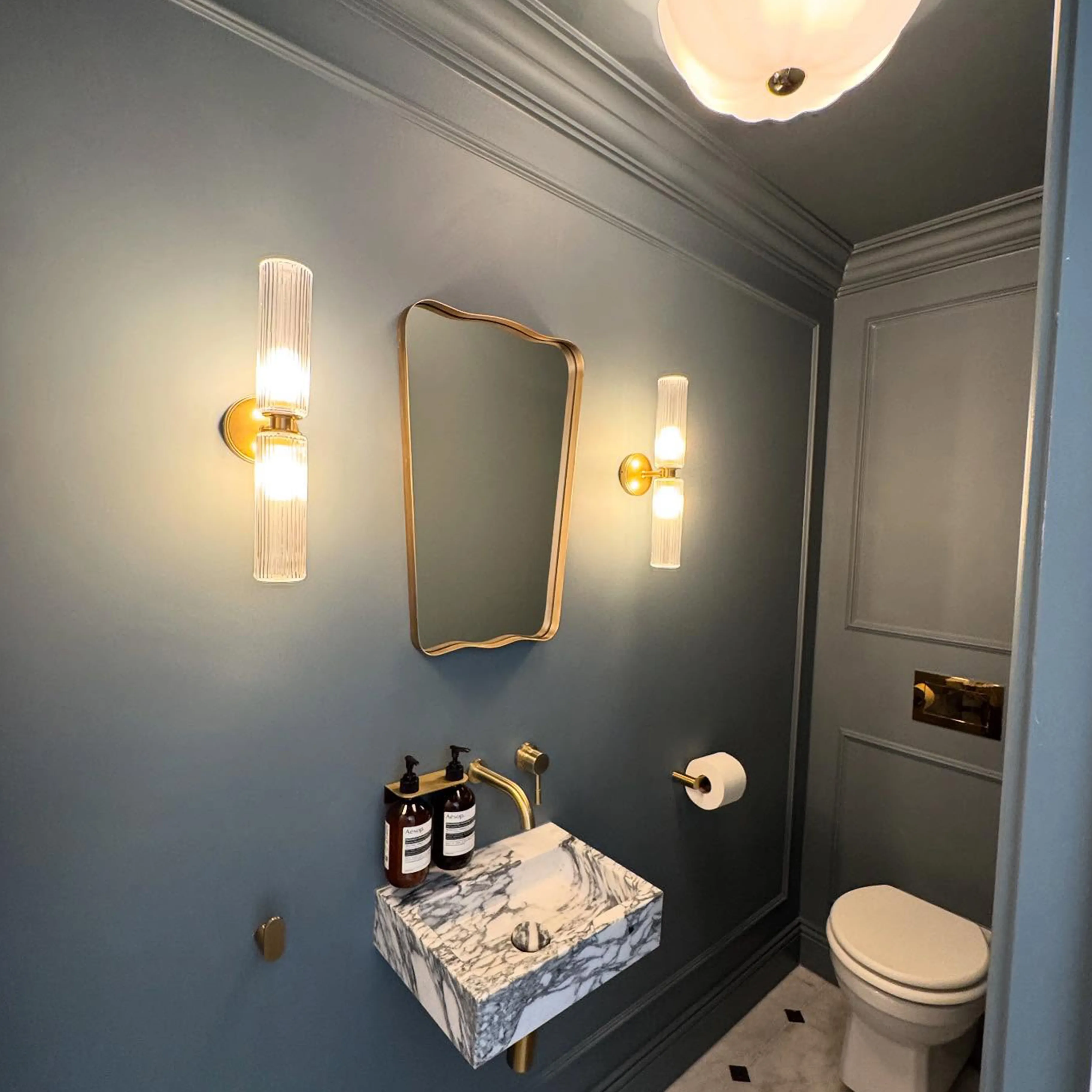 A bathroom with a sink, toilet and a mirror.