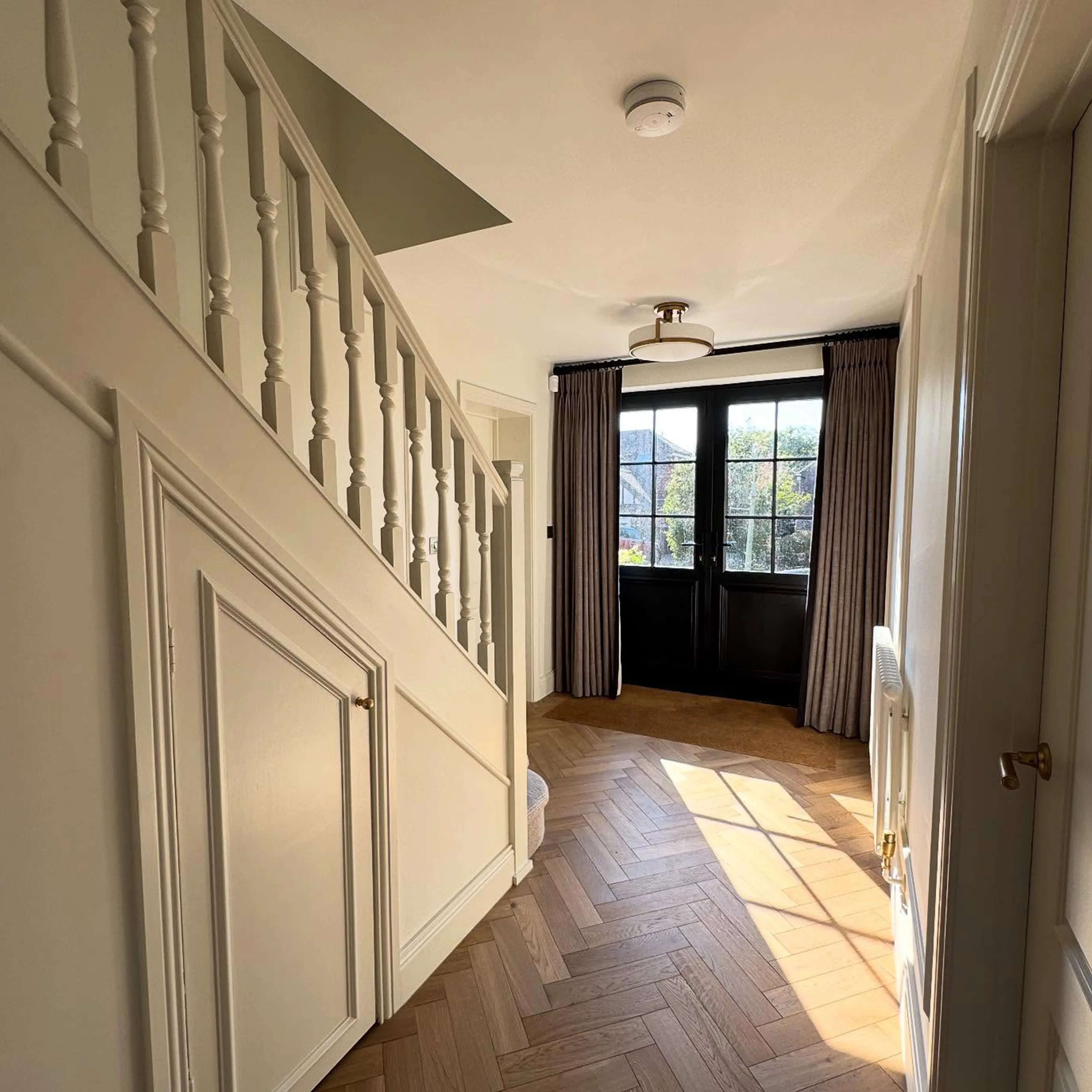 A hallway with a wooden floor and white walls.