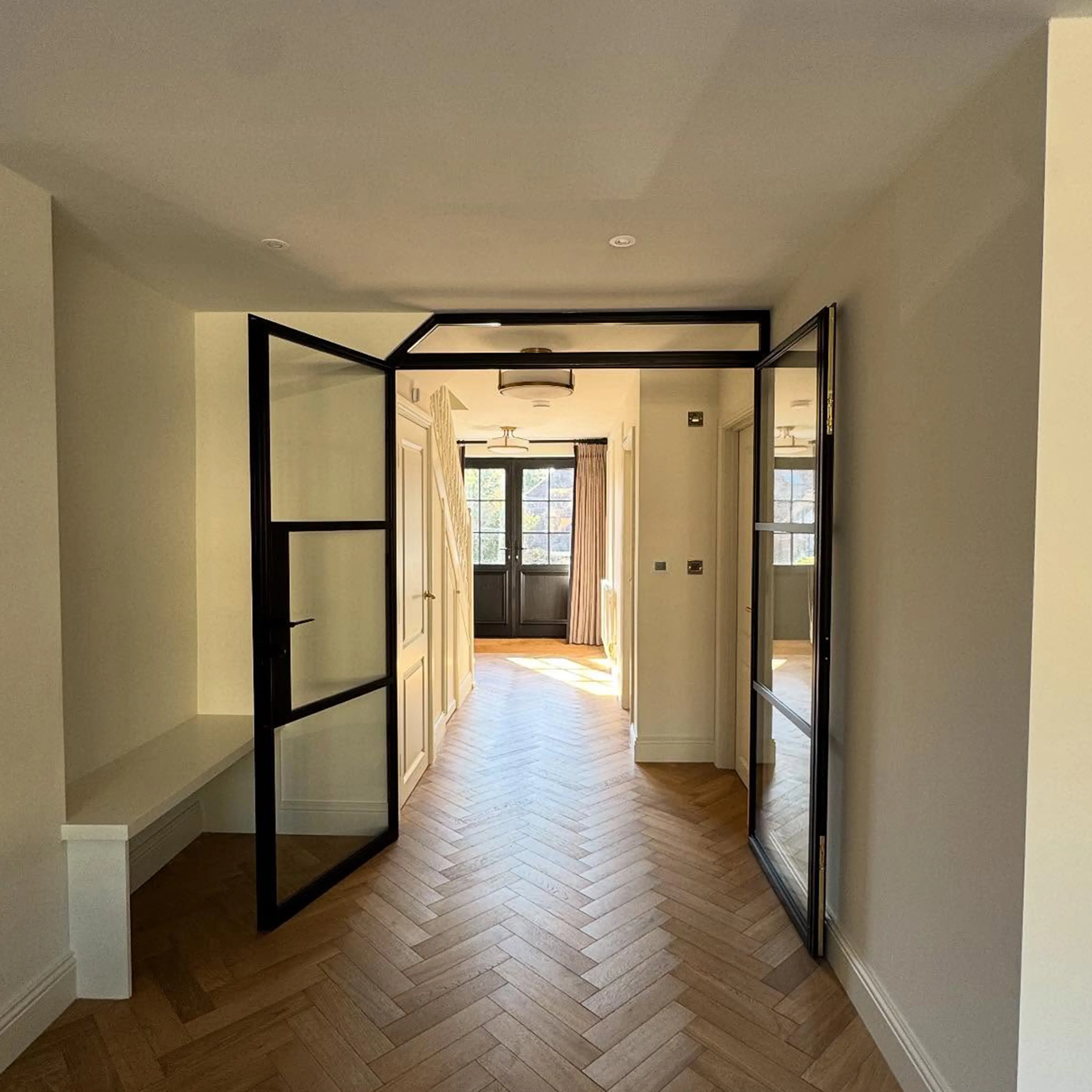 A hallway with a wooden floor and white walls.